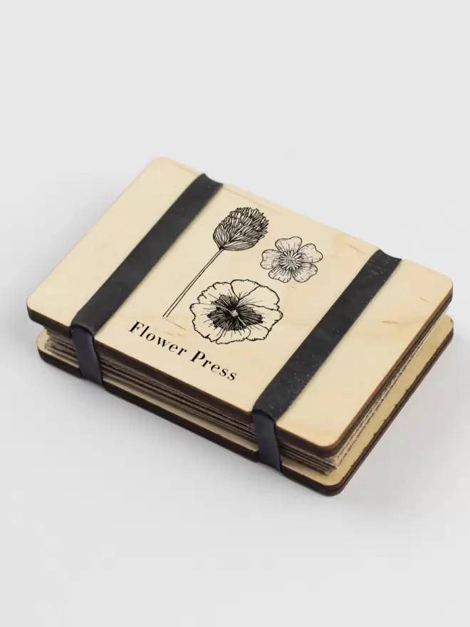 Mini flower press with floral illustration on the front