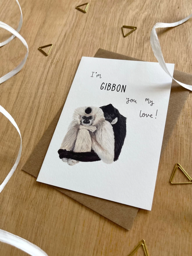 A greetings card featuring two gibbons sat side by side with the phrase “I’m gibbon you my love”