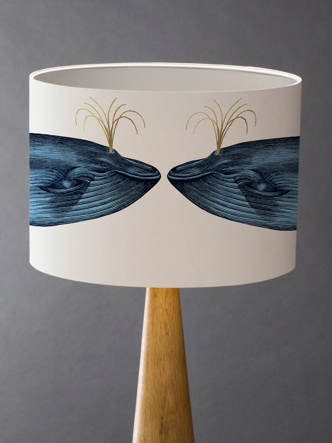 Blue Whale Drum Lampshade with white Inner  and Gold Detail on a wooden base 