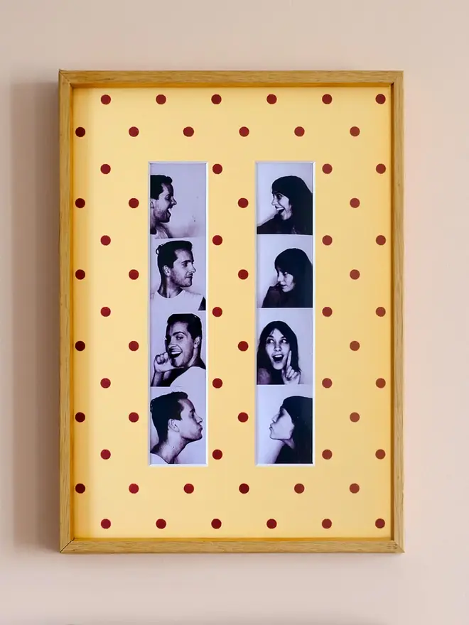 polka dot photo booth strip mount. a framed yellow polka dot photo mount with two photo strips inside.
