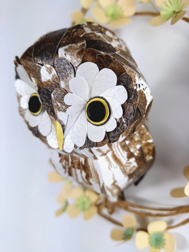 close up of a boreal owl sculpture, handmade from paper