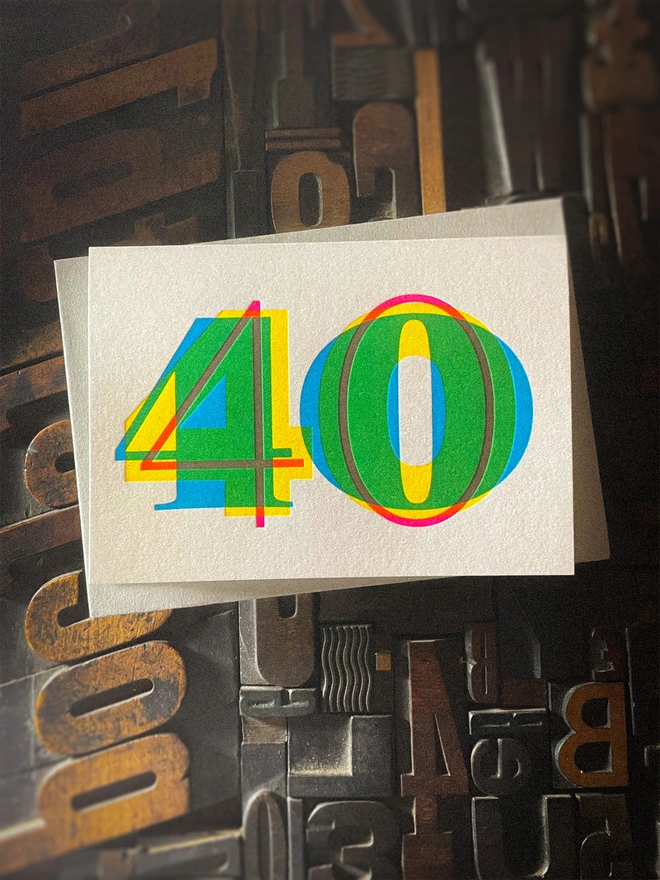 Contemporary handmade letterpress 40th birthday card featuring a bold oversized "50" in a vibrant typographic design. Printed using overlapping cyan, magenta and yellow inks to create striking secondary colours with a deep tactile letterpress impression. Individually hand printed on premium 350gsm GF Smith Colorplan card and paired with a high-quality 135gsm GF Smith Colorplan envelope in a complementary colour. Produced on a beautifully restored 1915 Arab Crown Folio press.