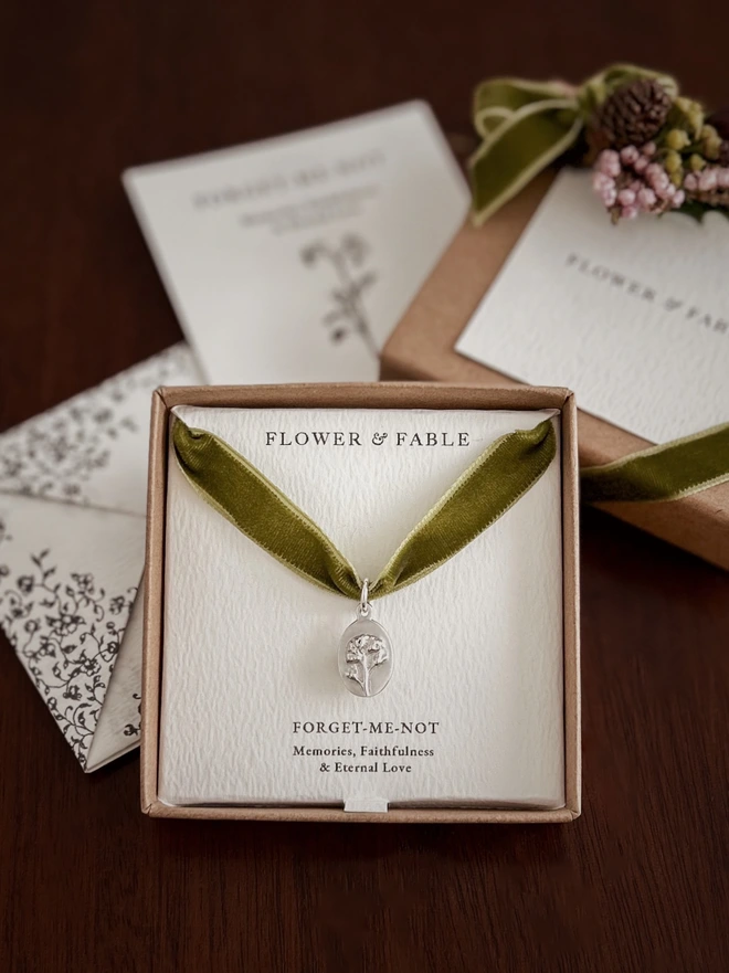 Sterling Silver Forget me not medal charm on a green ribbon and gift box with flower posy