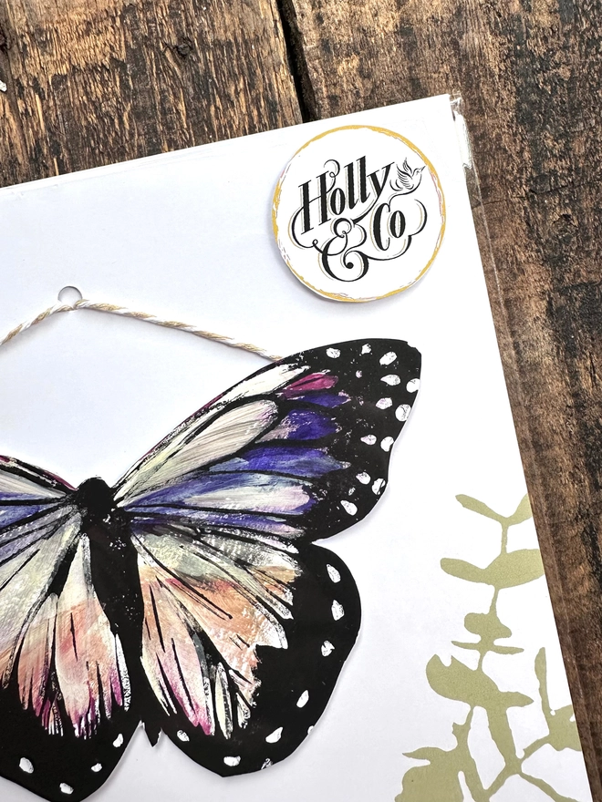 Hand Painted Butterfly Colourful Linocut Hanging Decoration In multiple colours and black the packaging has leaves on with the holly & co logo to the top right hand side