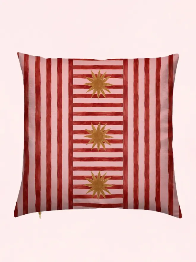 sun stripe cushion. a pink and burgundy striped cushion cover with a sun motif.