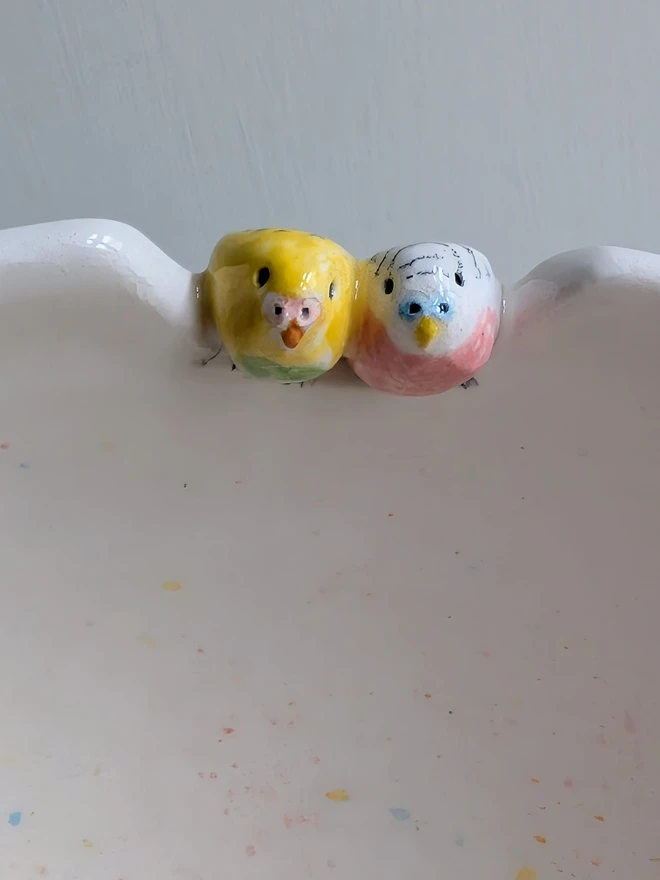 budgie couple bowl with quirky pink and yellow ceramic budgie perched on the edge