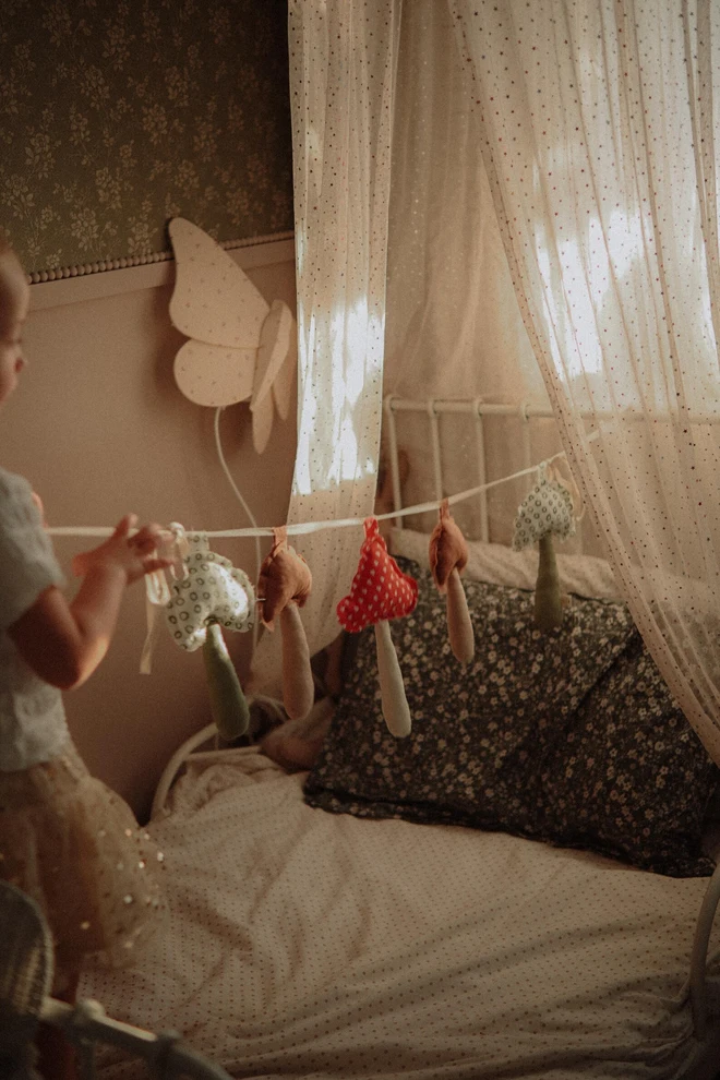 Mushroom Garland Decoration, a child playing with their hanging mushroom bunting in their bedroom.  