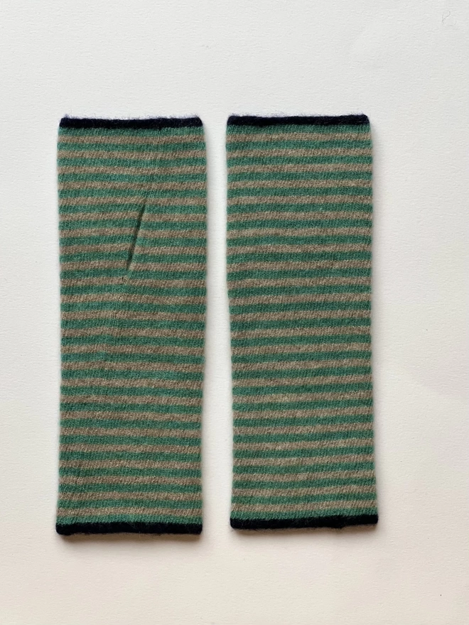Knitted striped wristwarmers laid flat next to each other 