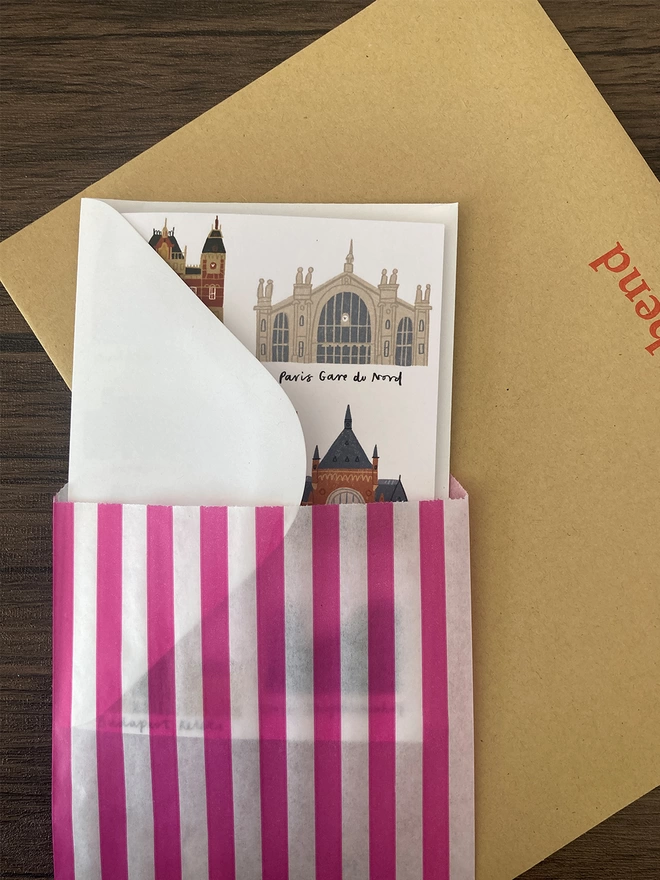 Train stations card packed with a white envelope inside a paper bag
