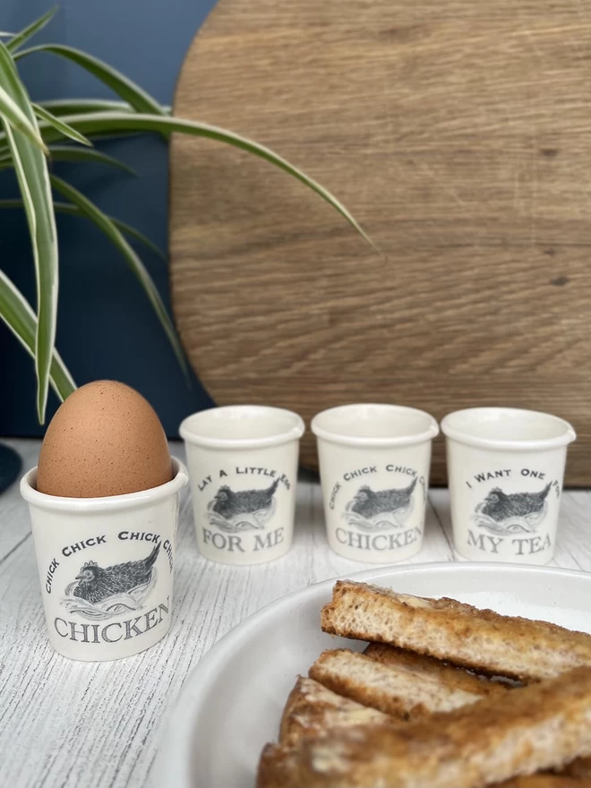 Set of 4 handmade egg cups, emulating a paper cup, with ‘ Chick Chick Chick CHICKEN’ song lyrics.