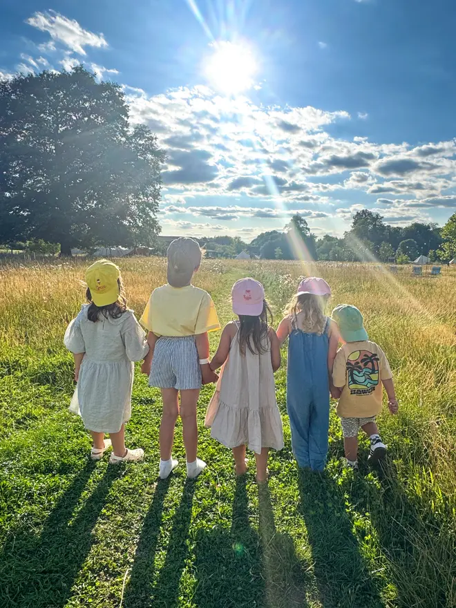 Group of children standing wearing hand-embroidered caps