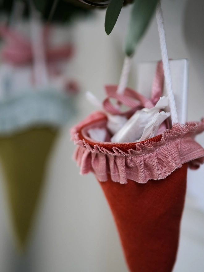 Reusable Victorian Christmas gift cones for hanging beneath festive greenery, featuring delicate ruffled trim.