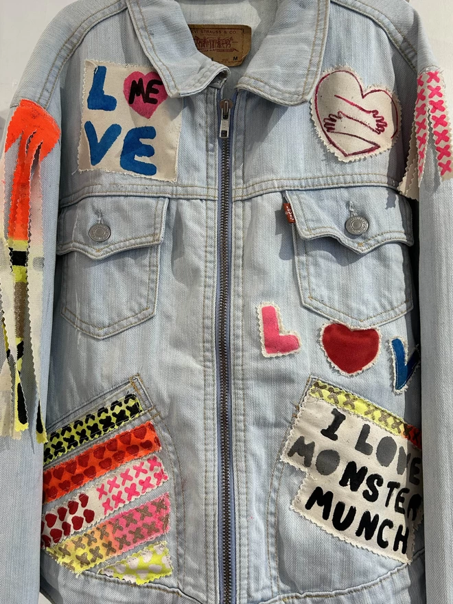 Image of a denim jacket decorated with different love patches