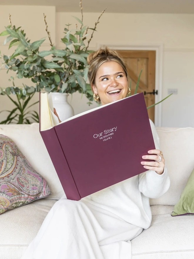 Luxurious Large Photo Album, being opened by a woman on a sofa. 