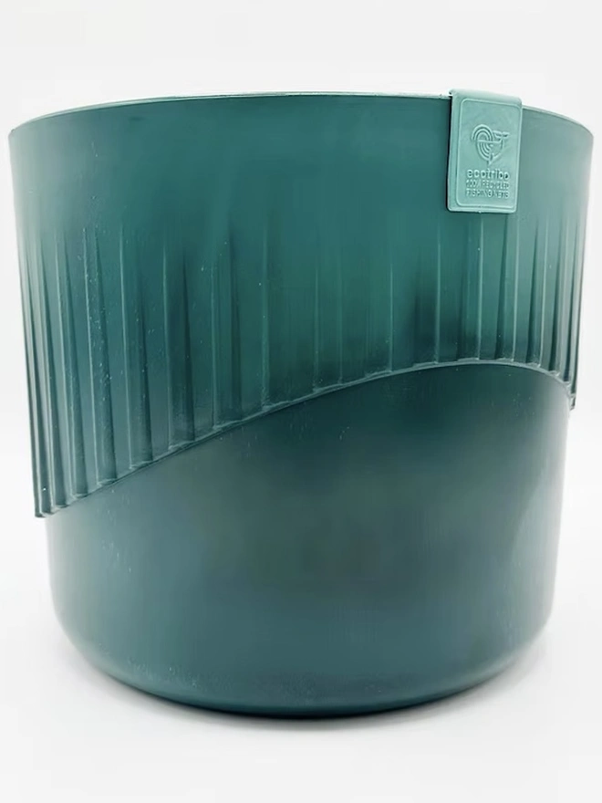 Ocean Plastic Plant Pot Medium, a recycled blue plant pot sitting on a plain surface against a white backdrop. 