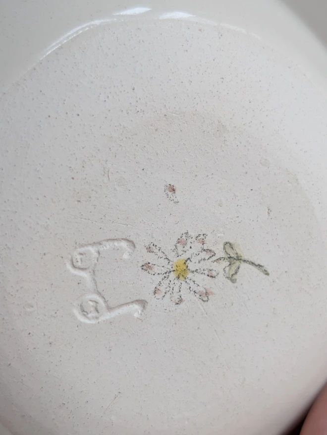 Base of ceramic planter with a hand painted daisy