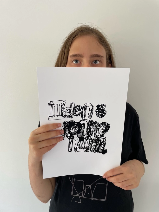Piper holding up her print in black ink font written on a white background