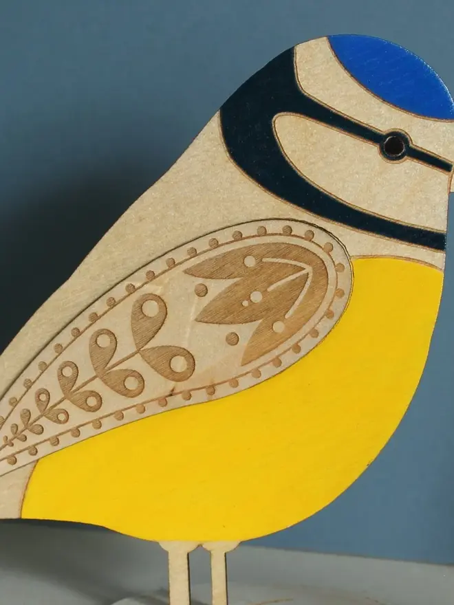 Standing Wooden Blue Tit, yellow wooden bird decoration standing on a platform. 