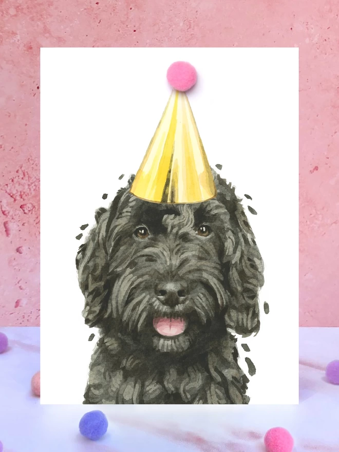 Black Cockapoo Pompom Birthday Celebration Collection Card in front of a pink background and surrounded by pompoms