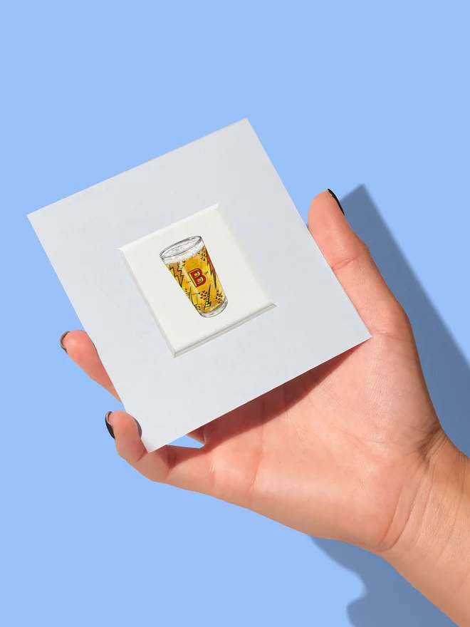 Hand holding a small print with mount showing the real size of the beer tiny print