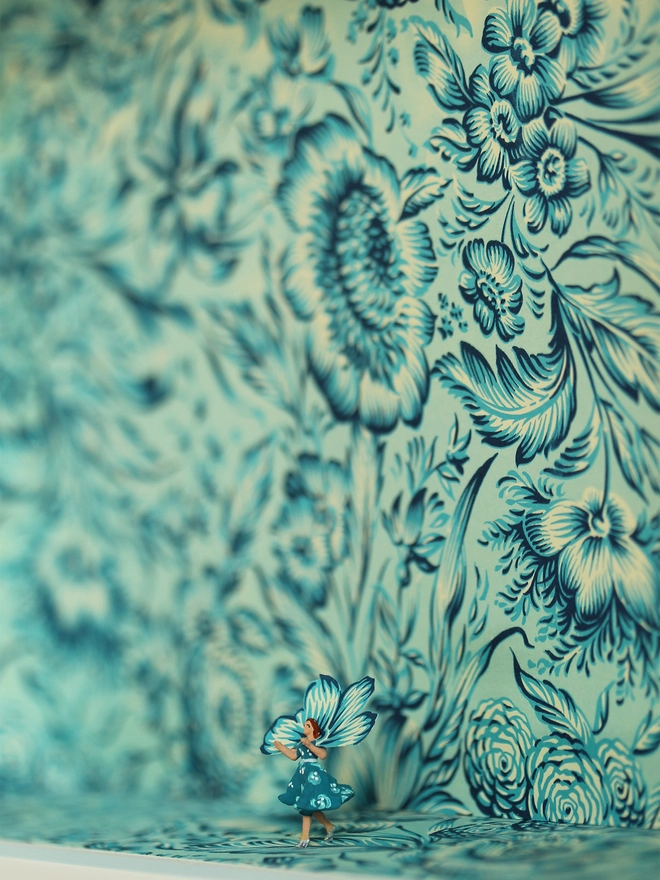 Miniature scene in an artbox showing a tiny lady in floral dress almost disappearing against matching floral wallpaper - close up