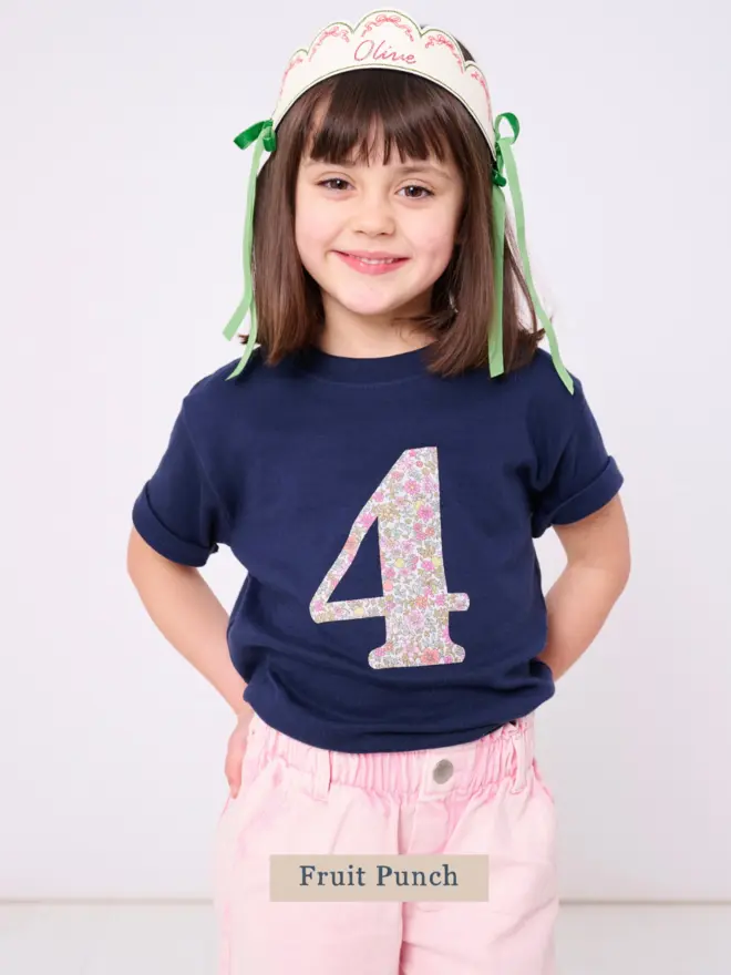 a 4 year old girl wearing a navy birthday t-shirt with a number 4 cut from liberty floral print on the front