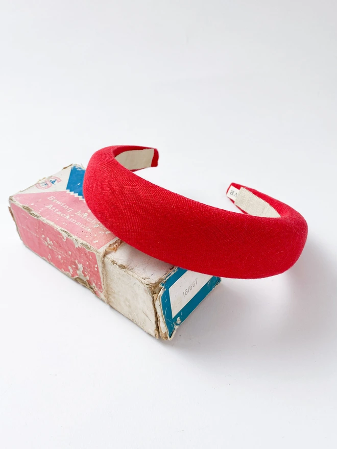 Red padded headband on vintage sewing box