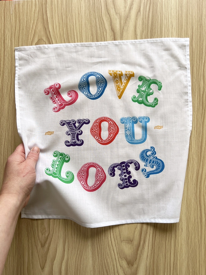 A Mr.PS Love You Lots Multicoloured Printed Handkerchief laid on a wooden table