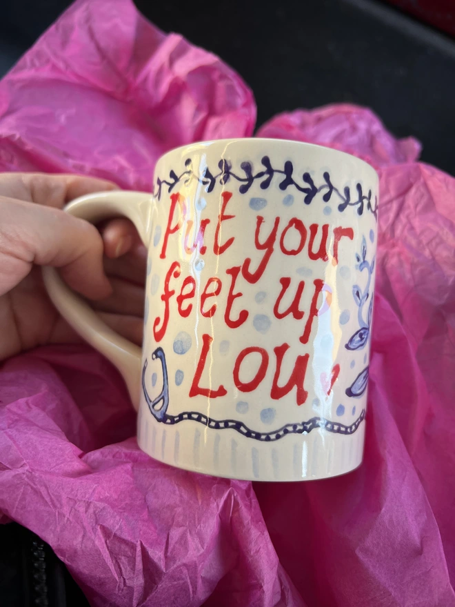 "Put your feet up Lou" in big hand-painted letters, with a stethoscope denoting her career as a doctor.  