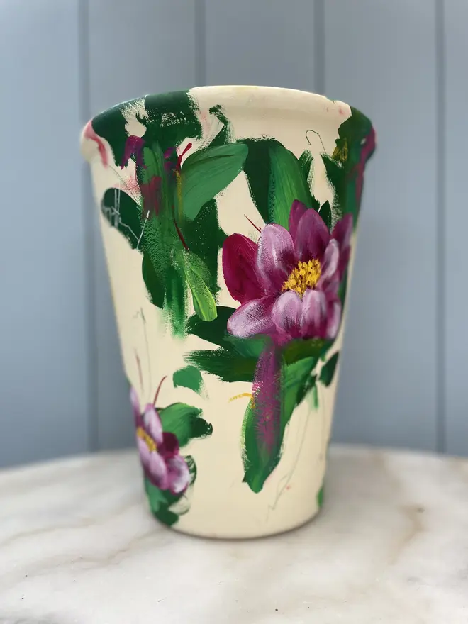 Unique hand-painted terracotta pot featuring pink peony on a cream background