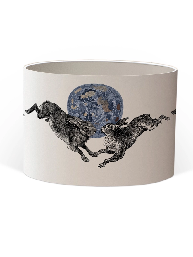 Drum Lampshade featuring a pair of hares leaping across a blue and silver moon with a white inner on a white background