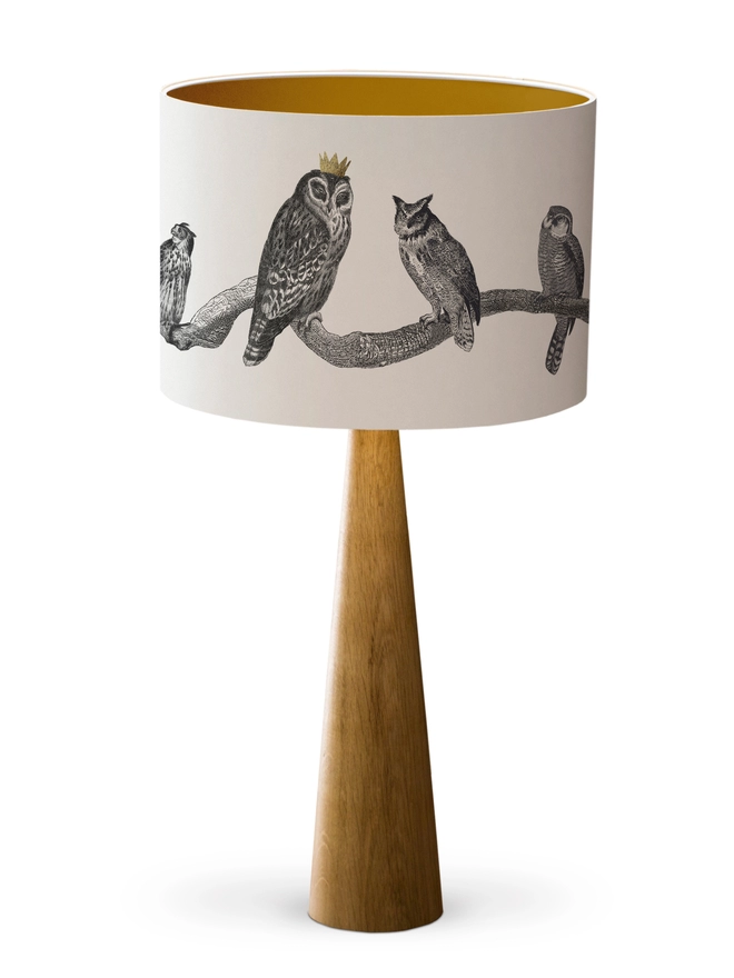 Drum Lampshade featuring owls on a branch with a gold inner on a wooden base on a white background