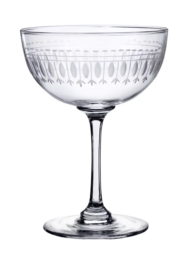 engraved ovals crystal champagne saucers. a round champagne glass engraved with a delicate oval pattern.