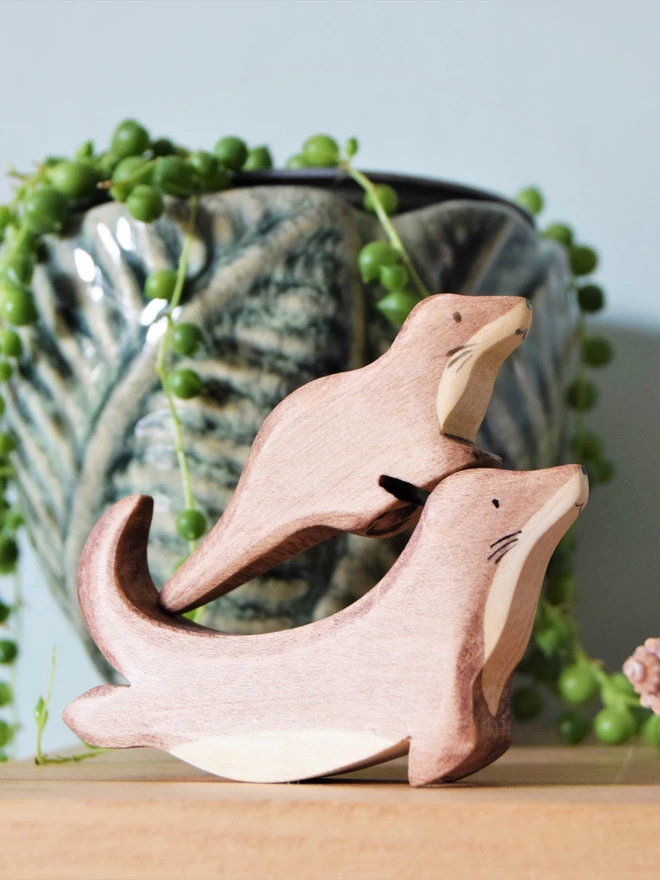 Playing toy otters on a wooden shelf 