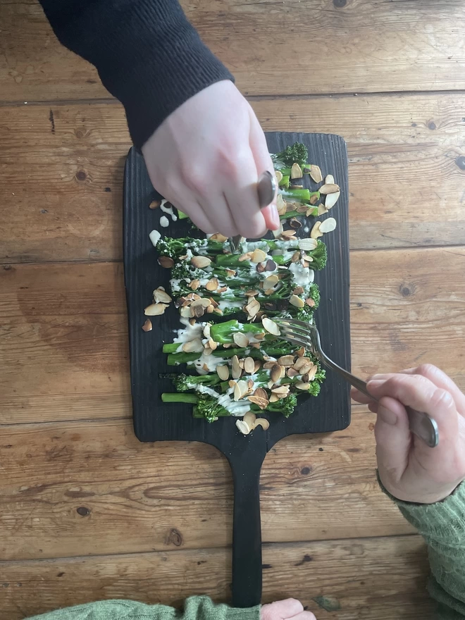 Digging into food on a Long Handle Charred Black Serving Board
