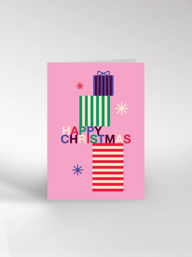 Contemporary illustrated Christmas card showing a stack of wrapped gifts and saying 'Happy Christmas'