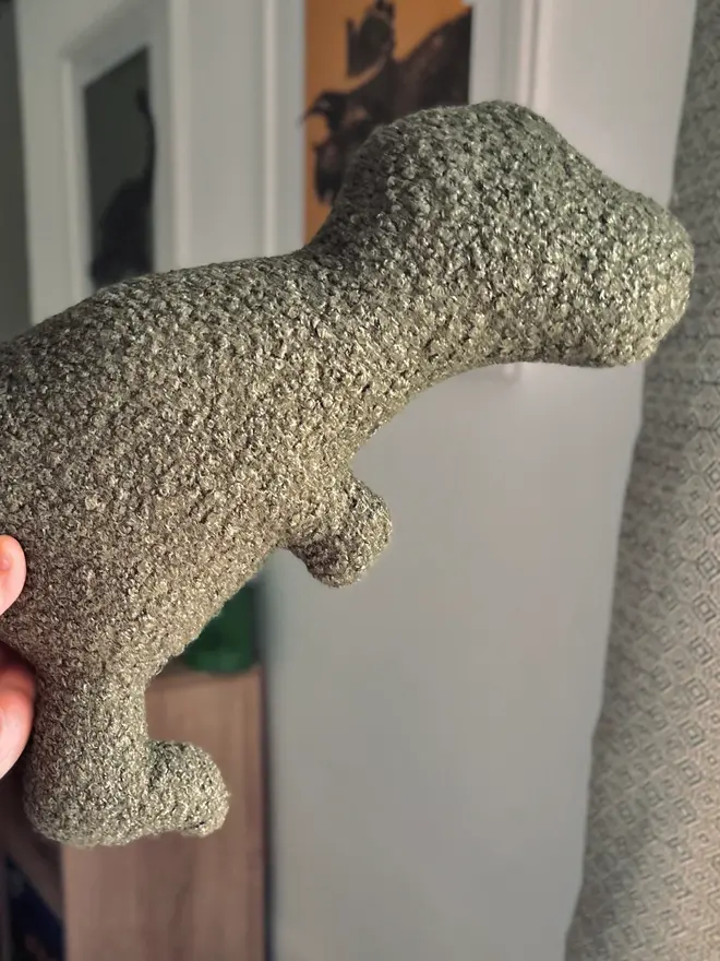 boucle dinosaur pillows. a green t-rex cushion.
