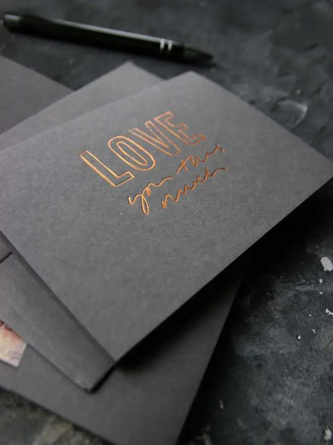 Hand foiled cash card or money wallet in a smoke grey colour in shiny bronze foil text which says ‘love you this much’.