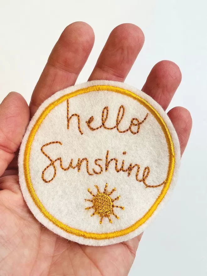 Hello sunshine patch being held in a hand to show scale.