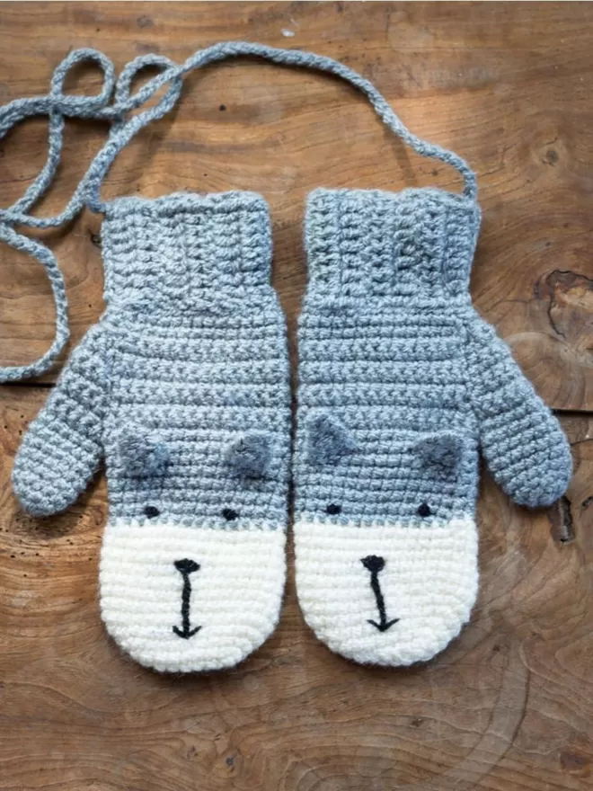 EKA Animal Mittens in grey seen on wooden floor.