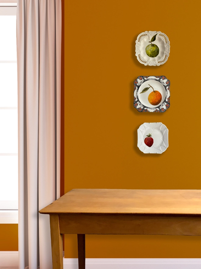 3 fruity plates on wall
