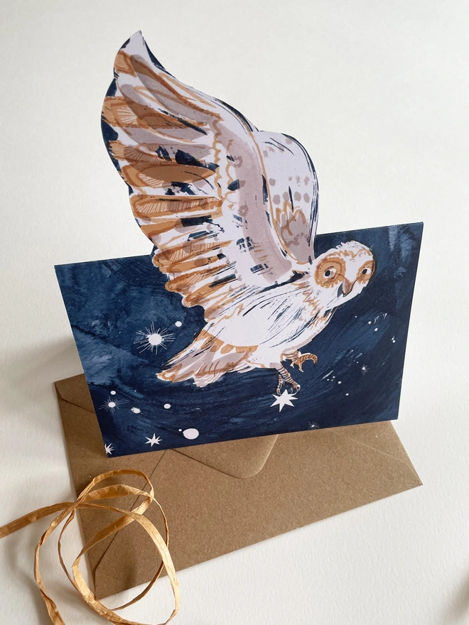 Esther Kent Night Owl illustrated greetings card shows a painterly white and brown owl on a dark blue sky. The wing folds out.