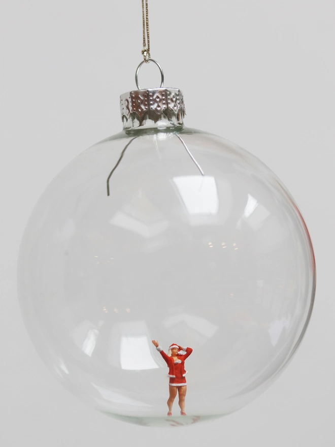 Miniature figure of a female santa in a glass Christmas bauble