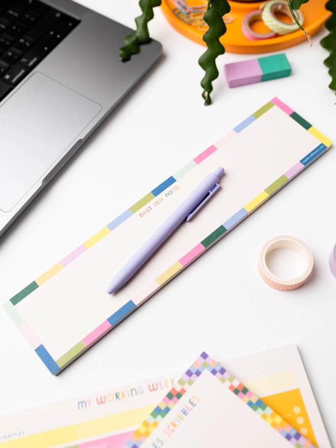 Keyboard notepad with ‘Daily desk notes’ in colourful hand lettering, with a rainbow tile design border 