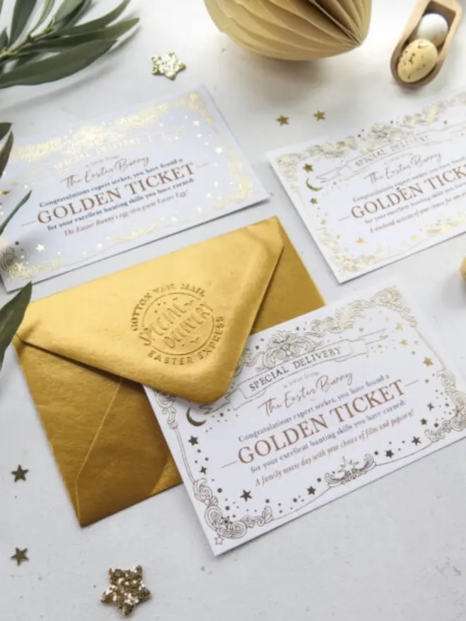 Three gold foil "Golden Ticket" cards from the Easter Bunny lie beside a shiny gold envelope embossed with "Cotton Tail Mail Easter Express." Each card rewards an expert egg hunter with a different treat, such as a family movie day.