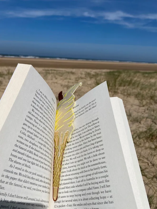 Ice cream embroidered bookmark in book on a Norfolk beach