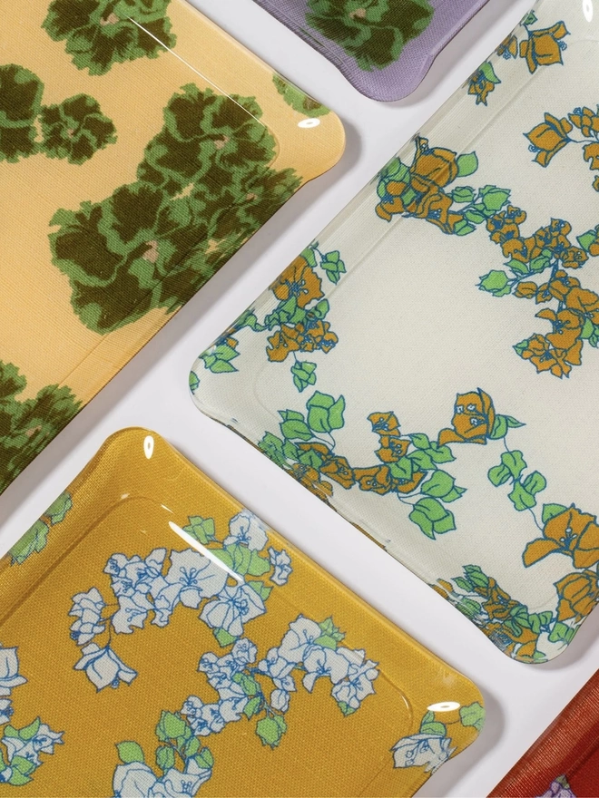 Acrylic Midi Tray, a group of colourful and patterned trays sitting on a plain surface. 