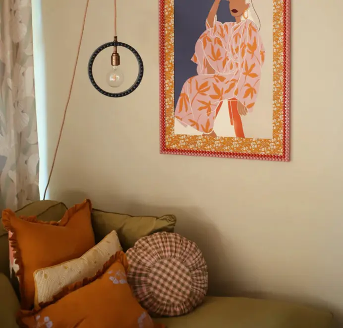 ring shaped pendant lamp in blue with bobbin rim hanging over living room couch