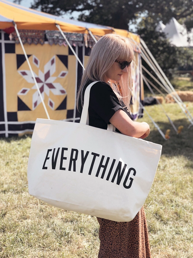 Model carrying the Everything oversized tote bag in natural canvas