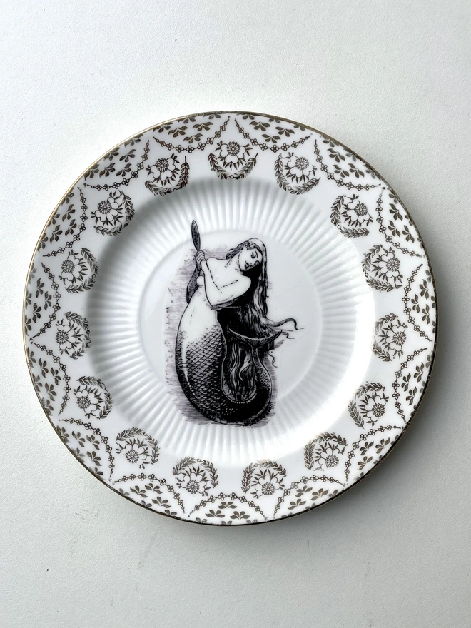 vintage plate with a gold ornate border and in the centre is a vintage illustration of a mermaid